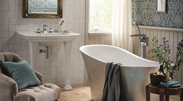 bathroom with white tiles and wooden floor. including feature bath tub and fabric lounge chair.